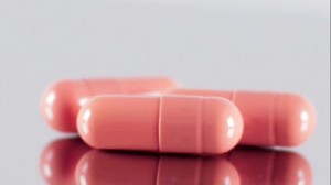 stock-footage-three-pink-capsules-rotate-on-a-plate-close-up-shot