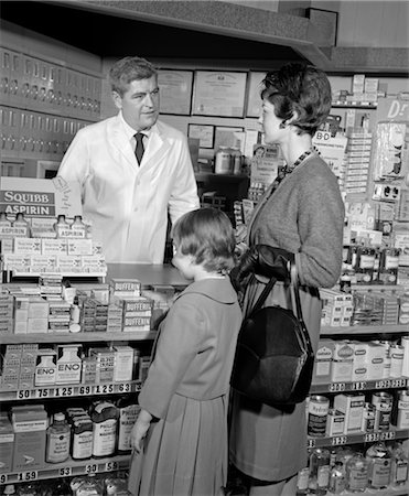 846-02796915 © ClassicStock / Masterfile Model Release: Yes Property Release: No 1950s 1960s MOTHER DAUGHTER COUNTER PHARMACY PHARMACIST BEHIND COUNTER SHELVES STOCKED ASPIRIN PRODUCTS MEDICINE